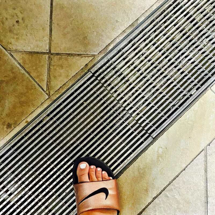 ACO K200 trench drain with a mesh grate in a tiled floor
