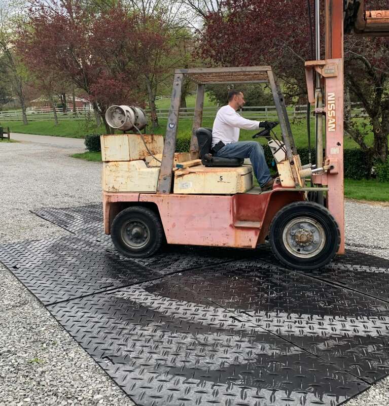 Forklift driving on Blue Gator ground protection mats
