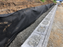 Non-woven geotextile drainage fabric behind a retaining wall with gravel backfill
