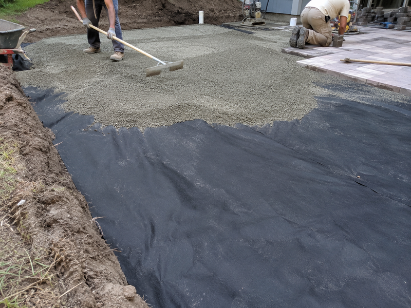 Non-woven geotextile fabric under the base layer of a paver patio installation
