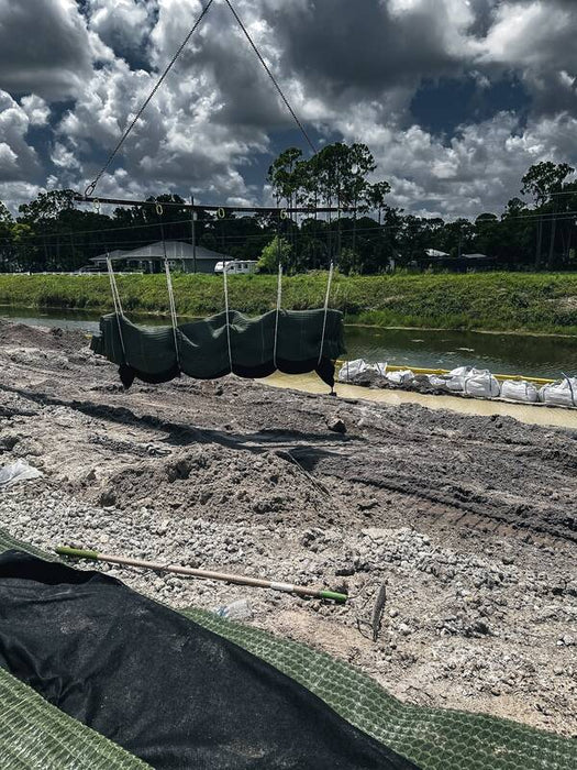 Crane placing Pyramat high performance turf reinforcement mat on a canal channel bank
