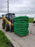 Pallet of coiled silt socks being loaded by a skid steer on a job site
